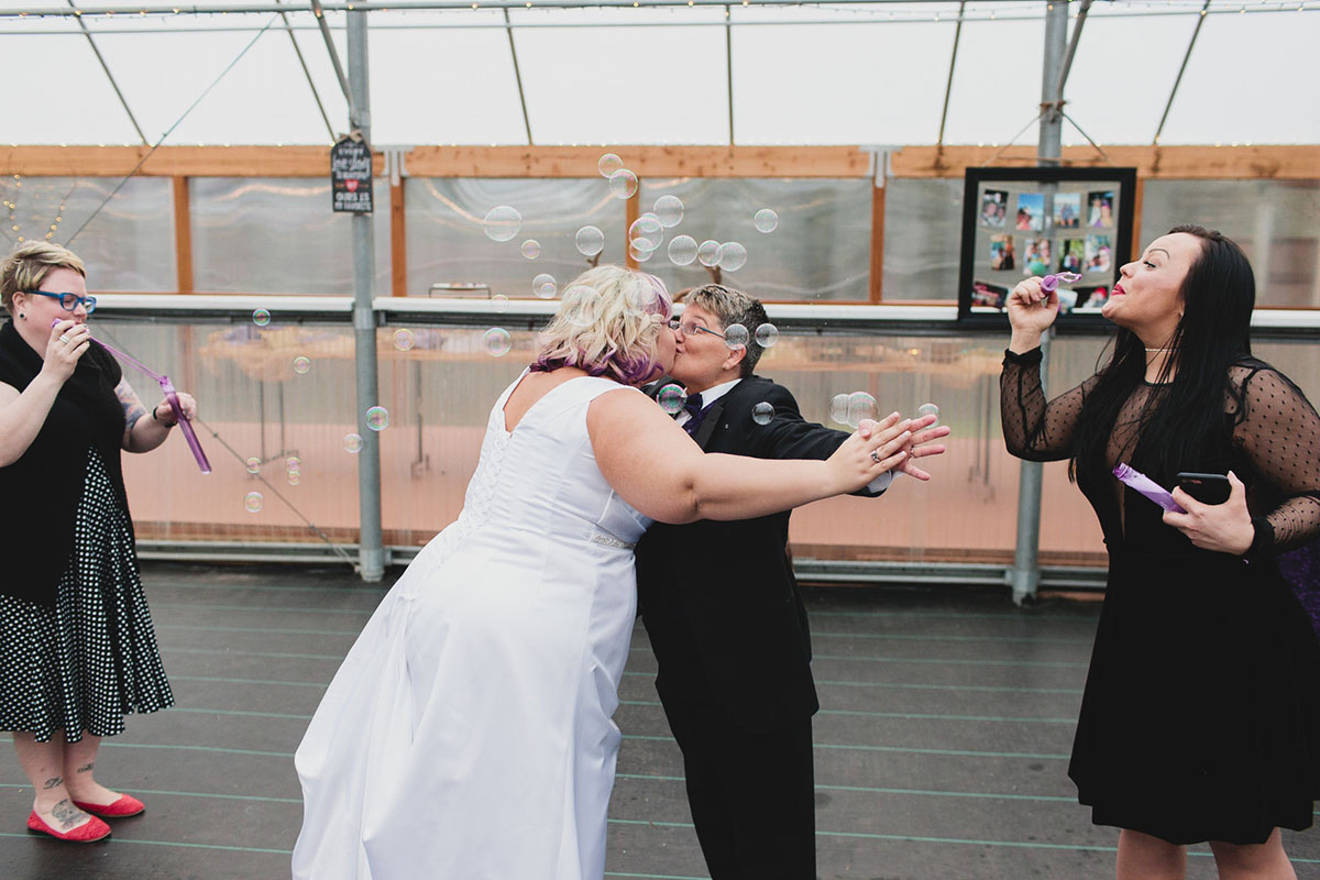 Purple greenhouse wedding with goats two brides lesbian wedding black tuxedo white dress dancing bubbles dance