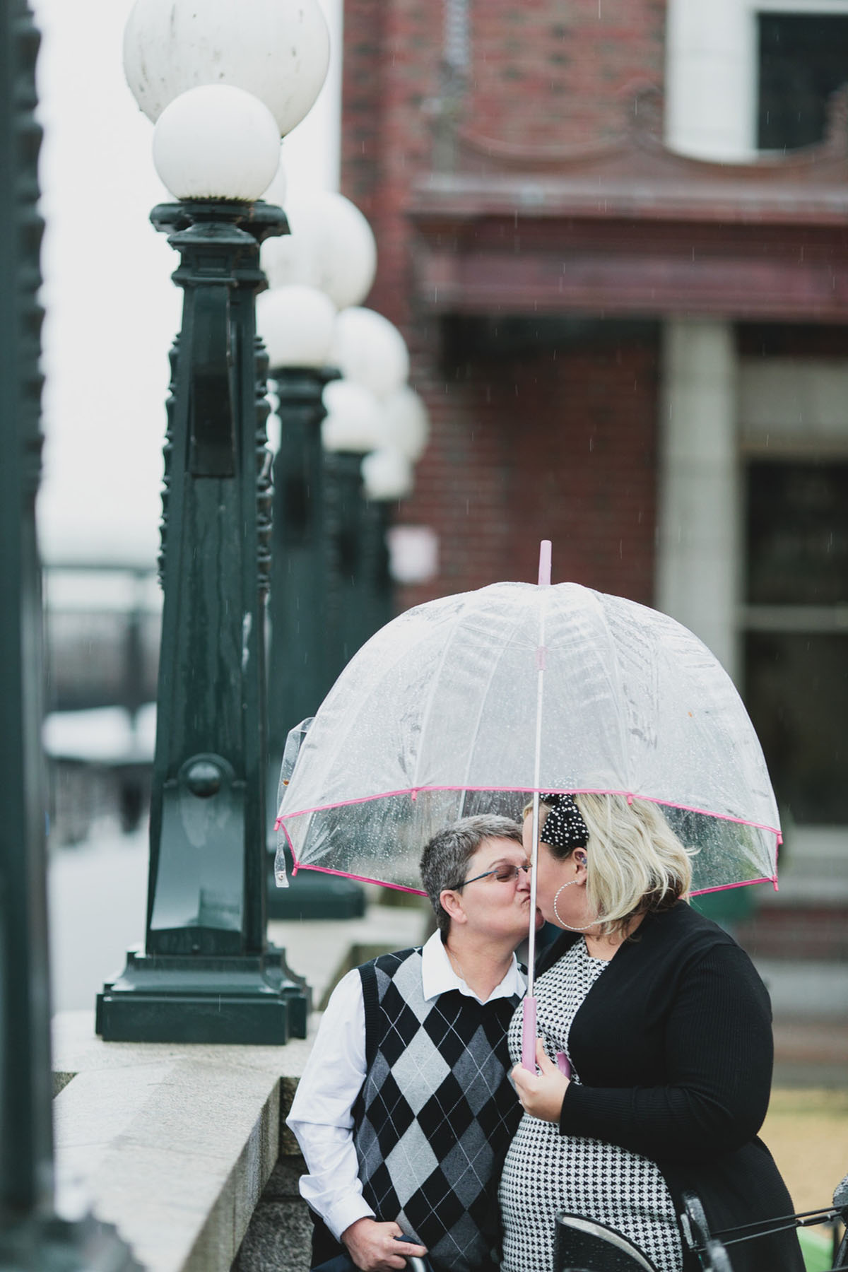 Vintage bus engagement photos in Seattle, Washington two brides argyle sweater houndstooth dress black and white rainy polka dot bow umbrella