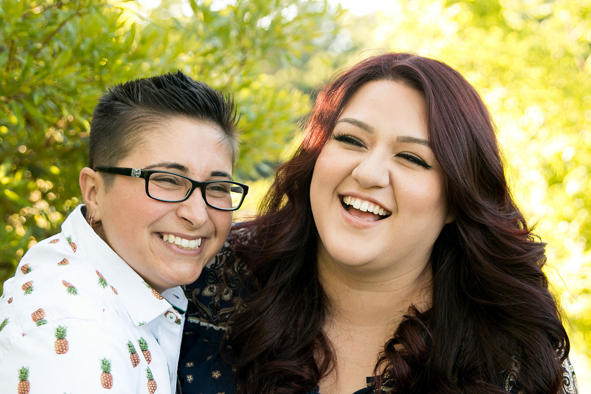 Outdoor engagement session in Pine Lake, Georgia two brides pineapple shirt glasses short hair burgundy hair