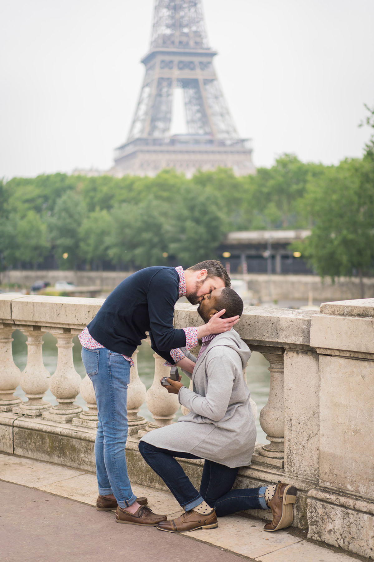 Proposal in front of the Eiffel Tower in Paris, France two grooms gay engagement surprise bridge