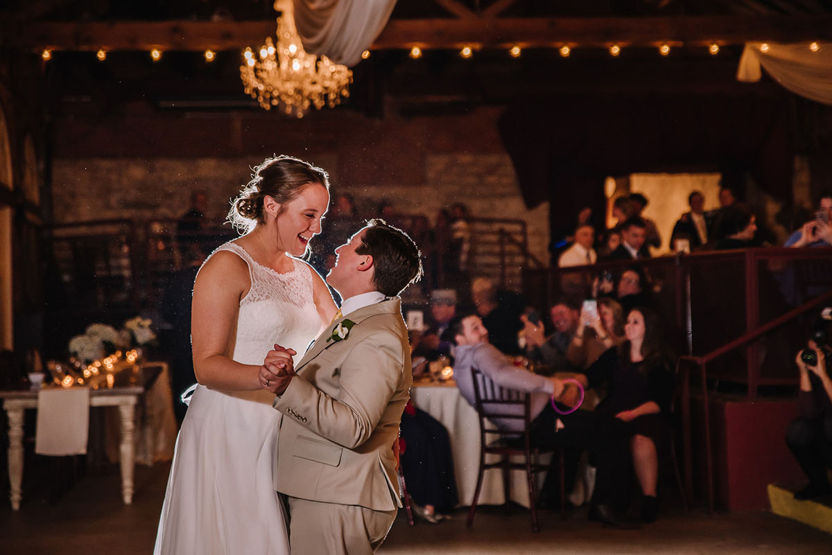 Rustic winery wedding in Columbus, Ohio exposed brick grey tuxedo long white tulle dress two brides first dance