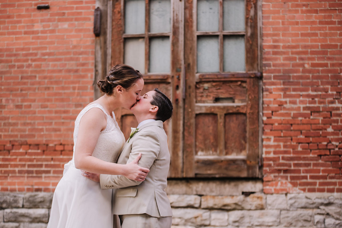 Rustic winery wedding in Columbus, Ohio exposed brick grey tuxedo long white tulle dress two brides first look