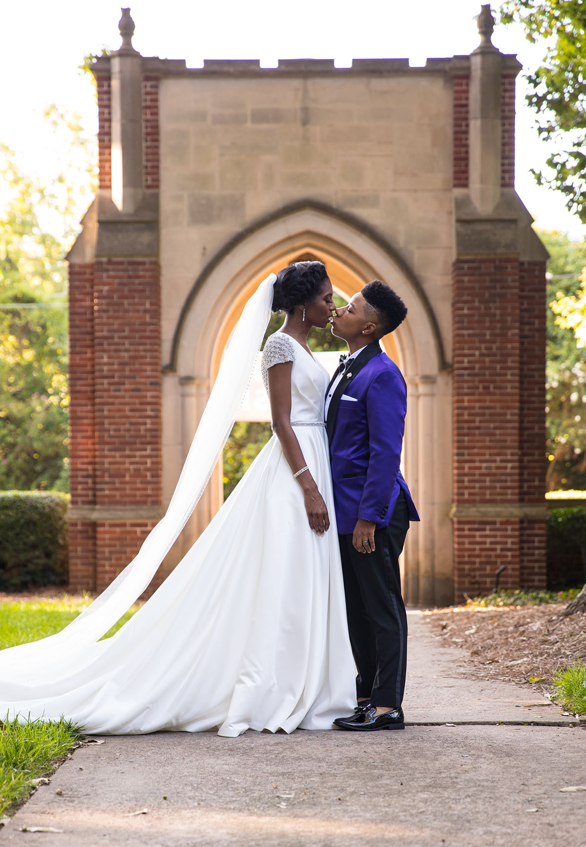 Southern traditional chapel wedding two brides purple tuxedo long white dress church God religious cultural traditions kiss