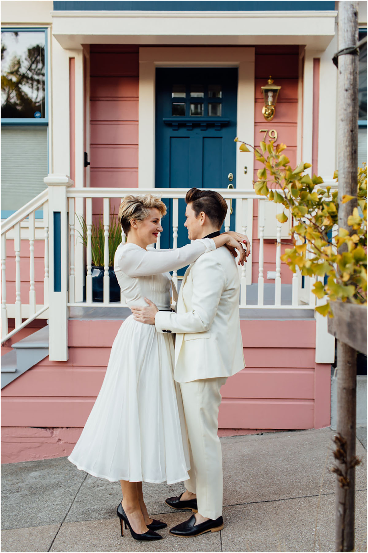 Stylish San Francisco, California, engagement tea length white dress short hair white tuxedo high heels pink house porch