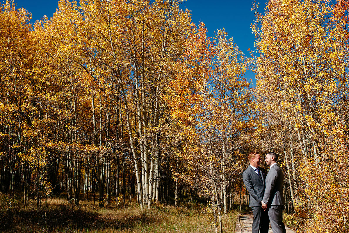 Fall mountain wedding in Aspen, Colorado two grooms steel grey tuxedos patterned ties foliage