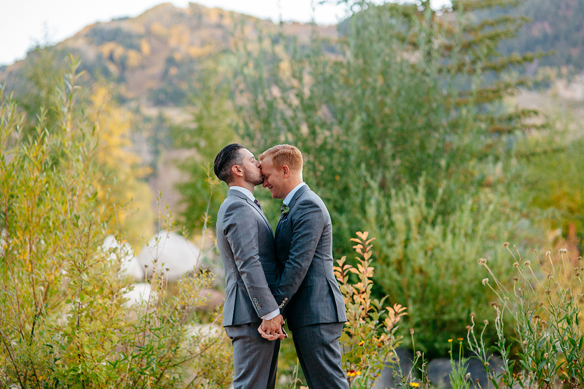 Fall mountain wedding in Aspen, Colorado two grooms steel grey tuxedos patterned ties kiss