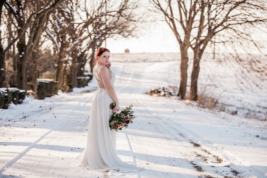 Historic mansion winter wedding inspiration two brides long white dresses up do snow
