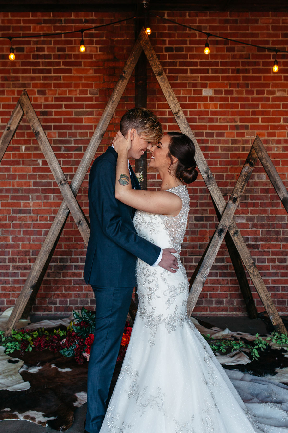 Mountain wedding inspiration in Denver, Colorado two brides blue tuxedo long white dress rustic exposed brick