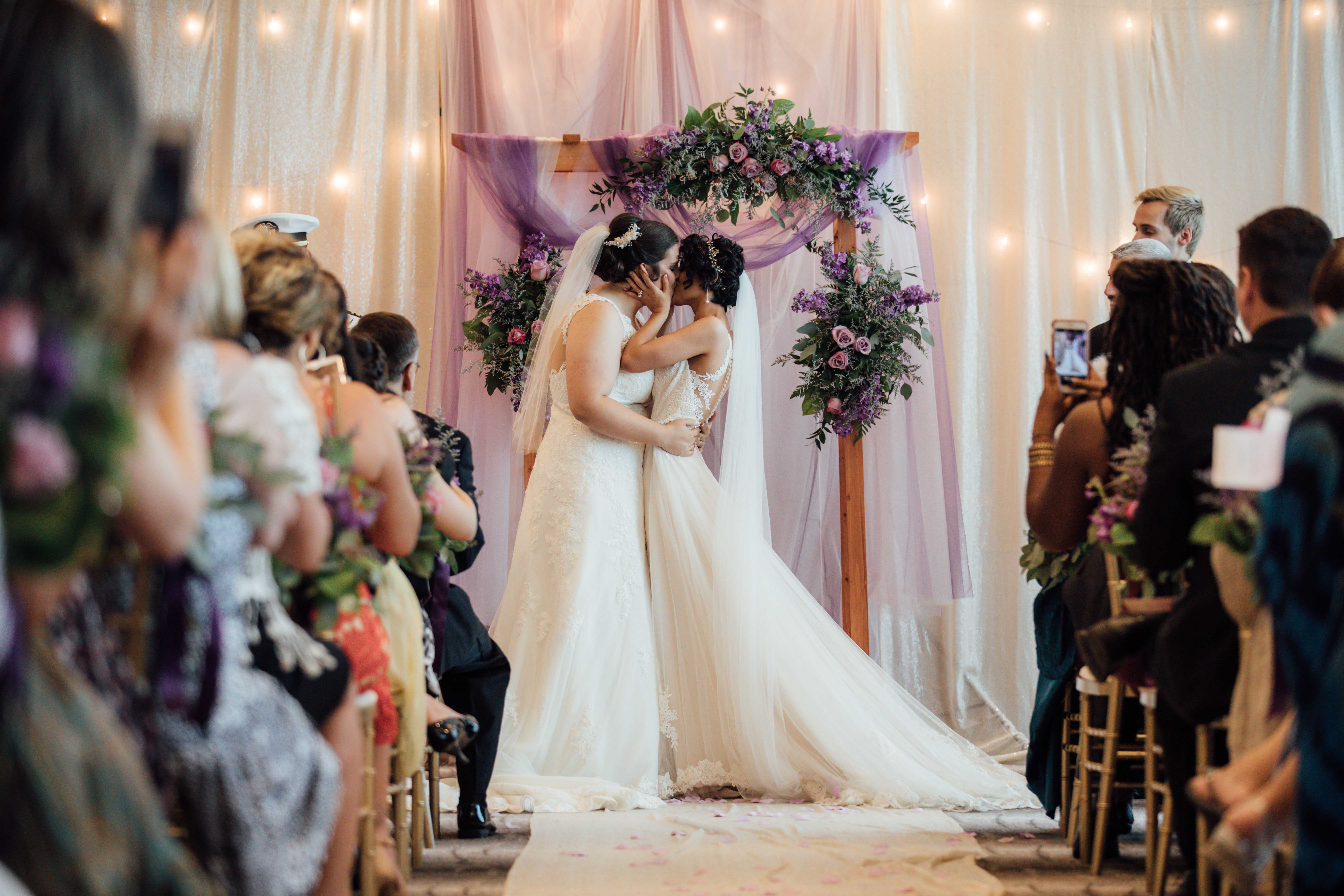 Purple summer wedding in Pittsburgh, Pennsylvania two brides long white dresses bouquets kiss