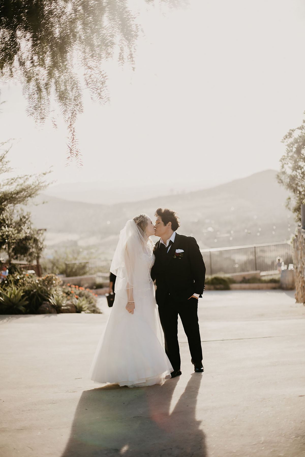Romantic hillside winery wedding two brides long white dress black tuxedo tux
