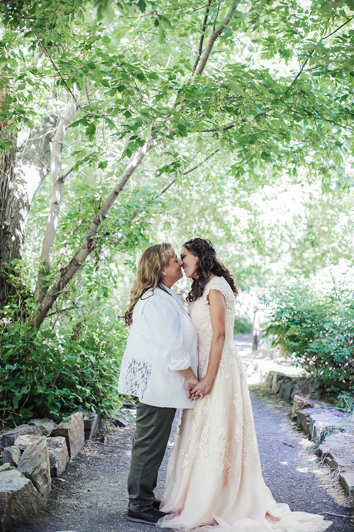 Eclectic bohemian mountain fairytale wedding two brides long tulle champagne dress Lane Bryant outfit flowers nature kiss