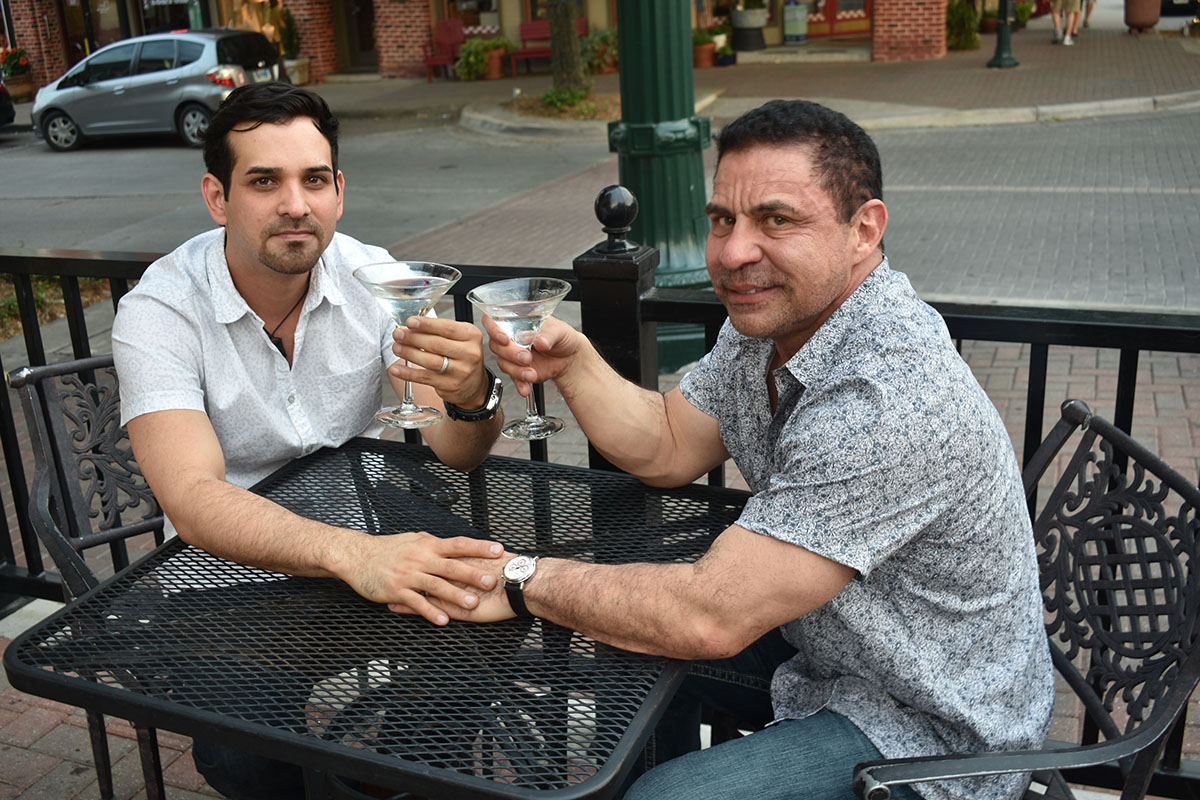 Engagement photos in historic McKinney, Texas two grooms downtown casual martinis