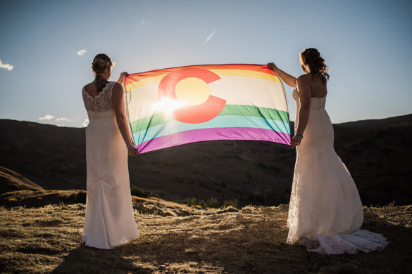 Mountain elopement on Loveland Pass Colorado two brides intimate wedding BHLDN Bonny Bridal white dresses rainbow flag
