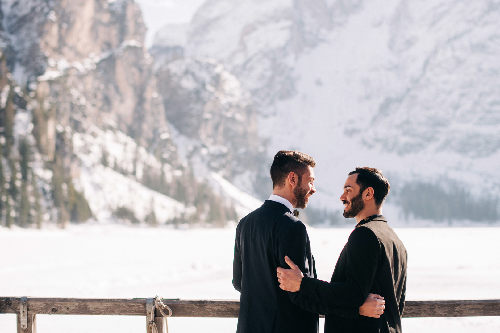 This winter mountain elopement on the Dolomites in Italy is seriously cozy two grooms black tuxedos tux snowy March mountains Lake Braies
