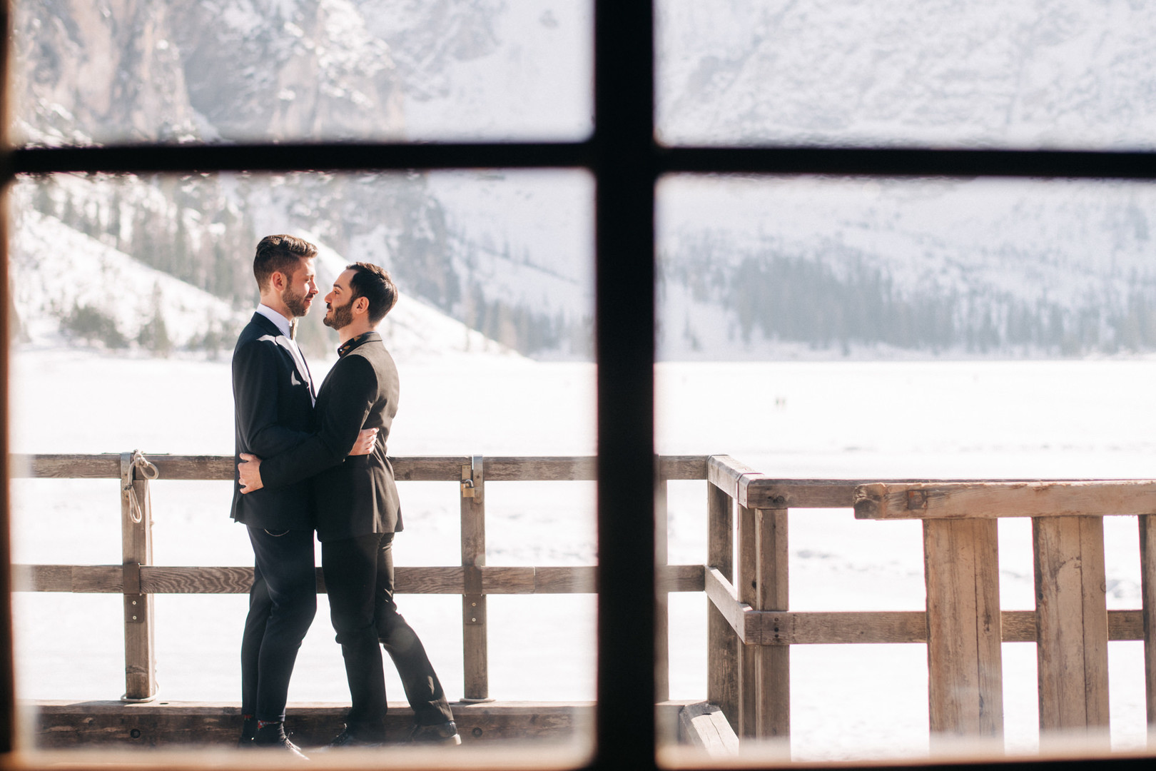 This winter mountain elopement on the Dolomites in Italy is seriously cozy two grooms black tuxedos tux snowy March mountains Lake Braies