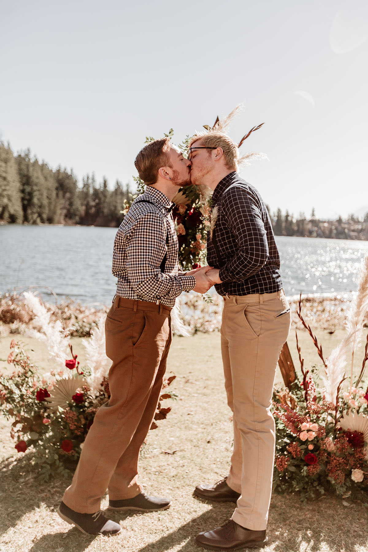 Iridescent bohemian wedding inspiration for the nature lover two grooms gingham plaid suspenders waterfront kiss