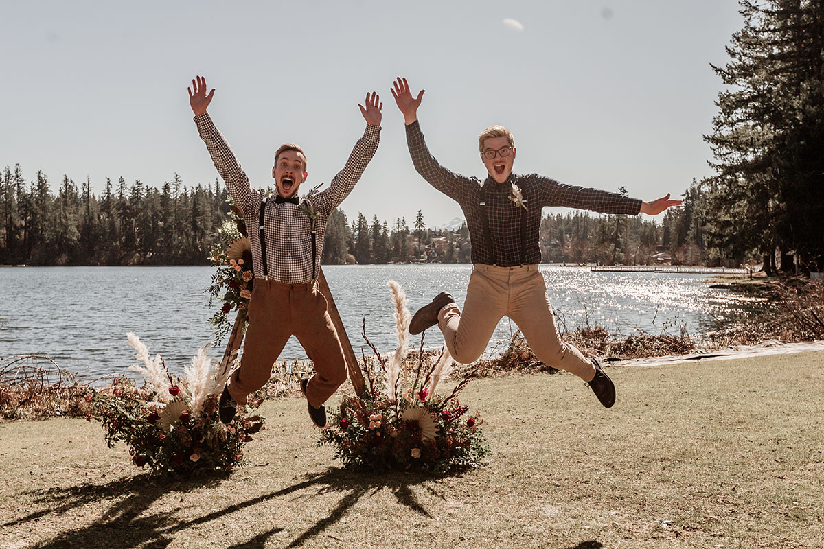 Iridescent bohemian wedding inspiration for the nature lover two grooms gingham plaid suspenders waterfront jump