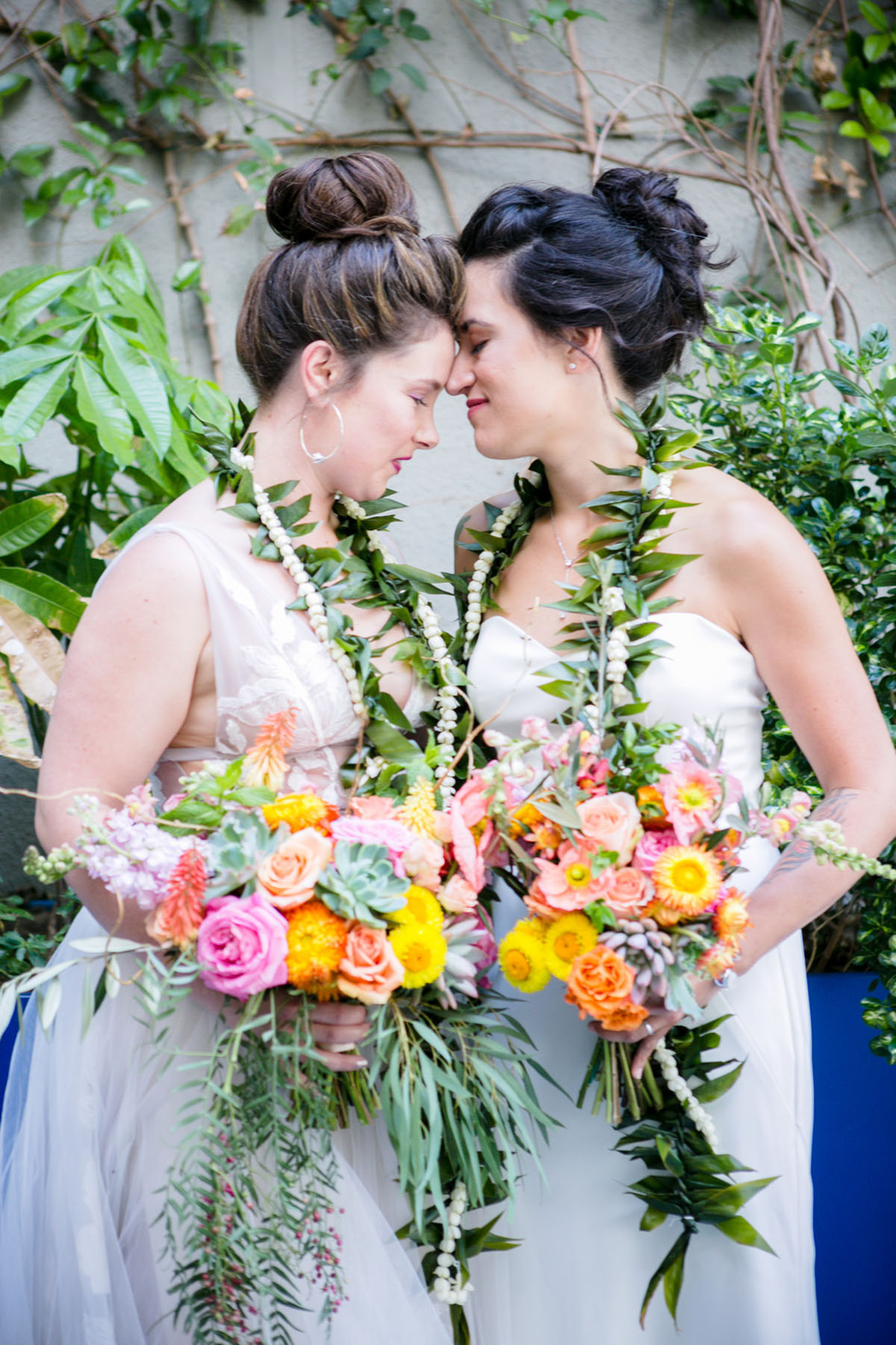Modern intimate destination wedding with Hawaiian traditions two brides white dresses bright neon flowers colorful leis