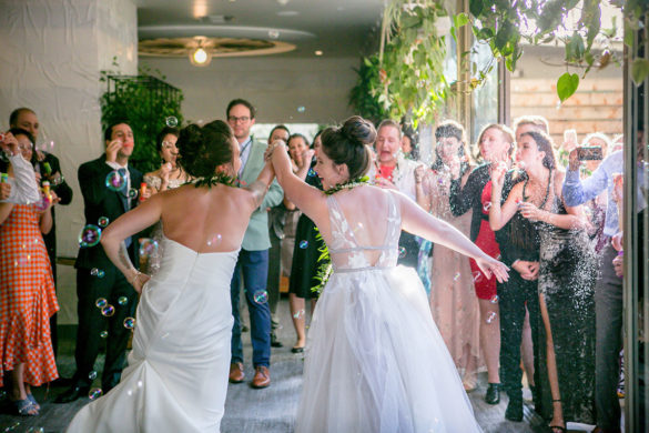 Modern intimate destination wedding with Hawaiian traditions two brides white dresses bubble entrance