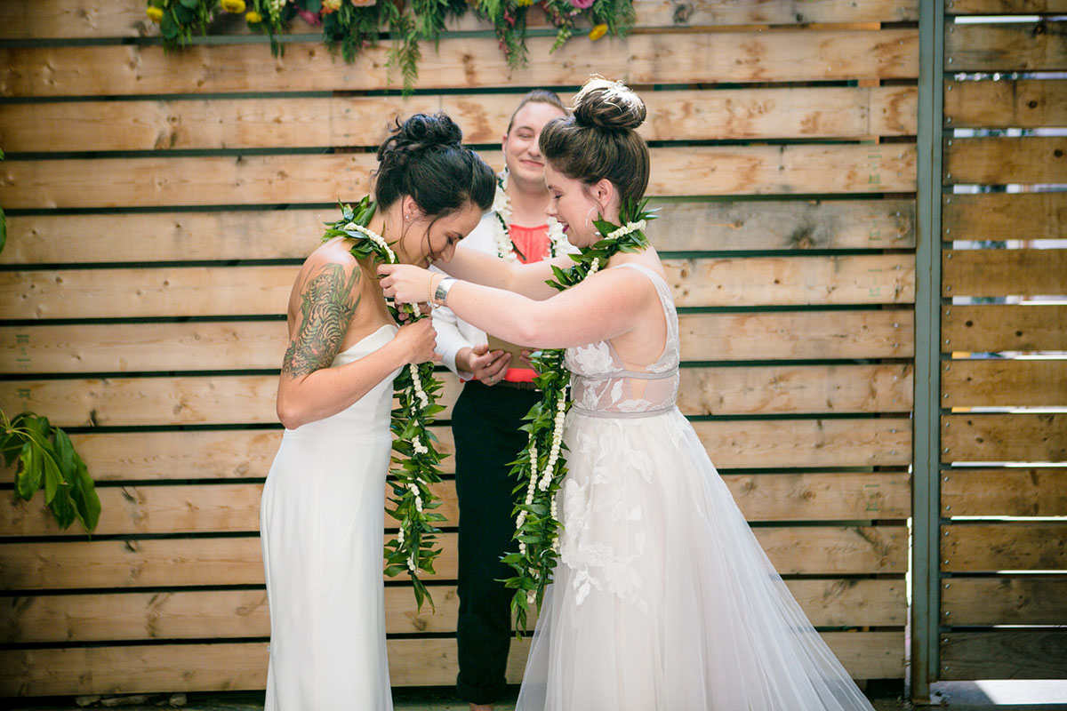 Modern intimate destination wedding with Hawaiian traditions two brides white dresses vows leis