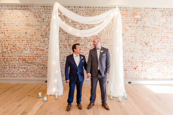Rustic and romantic wedding inspiration in Charleston, South Carolina two grooms blue tux gray tux oyster shell bow ties fairy lights brick wall
