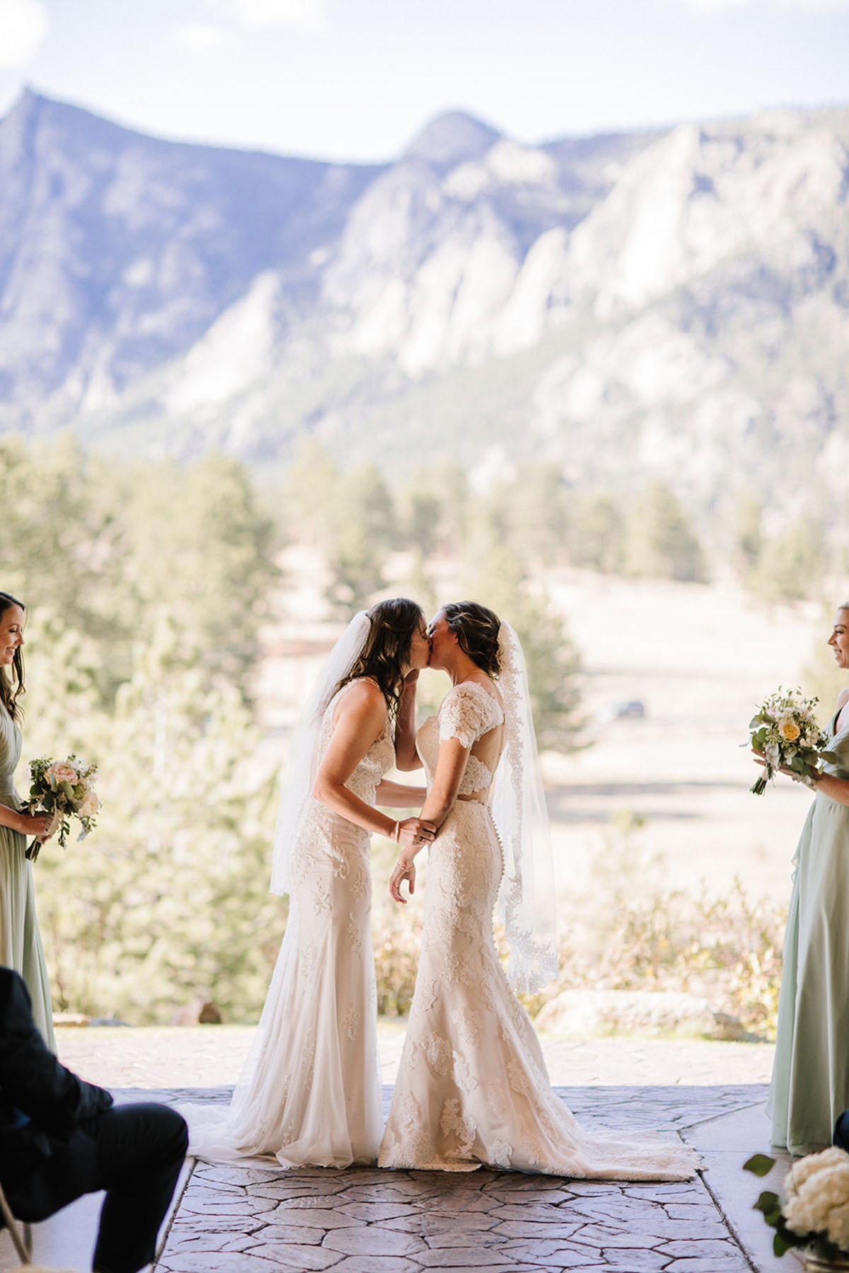 Rustic mountain wedding in the Colorado Rocky Mountains two brides lace white dresses veils kiss