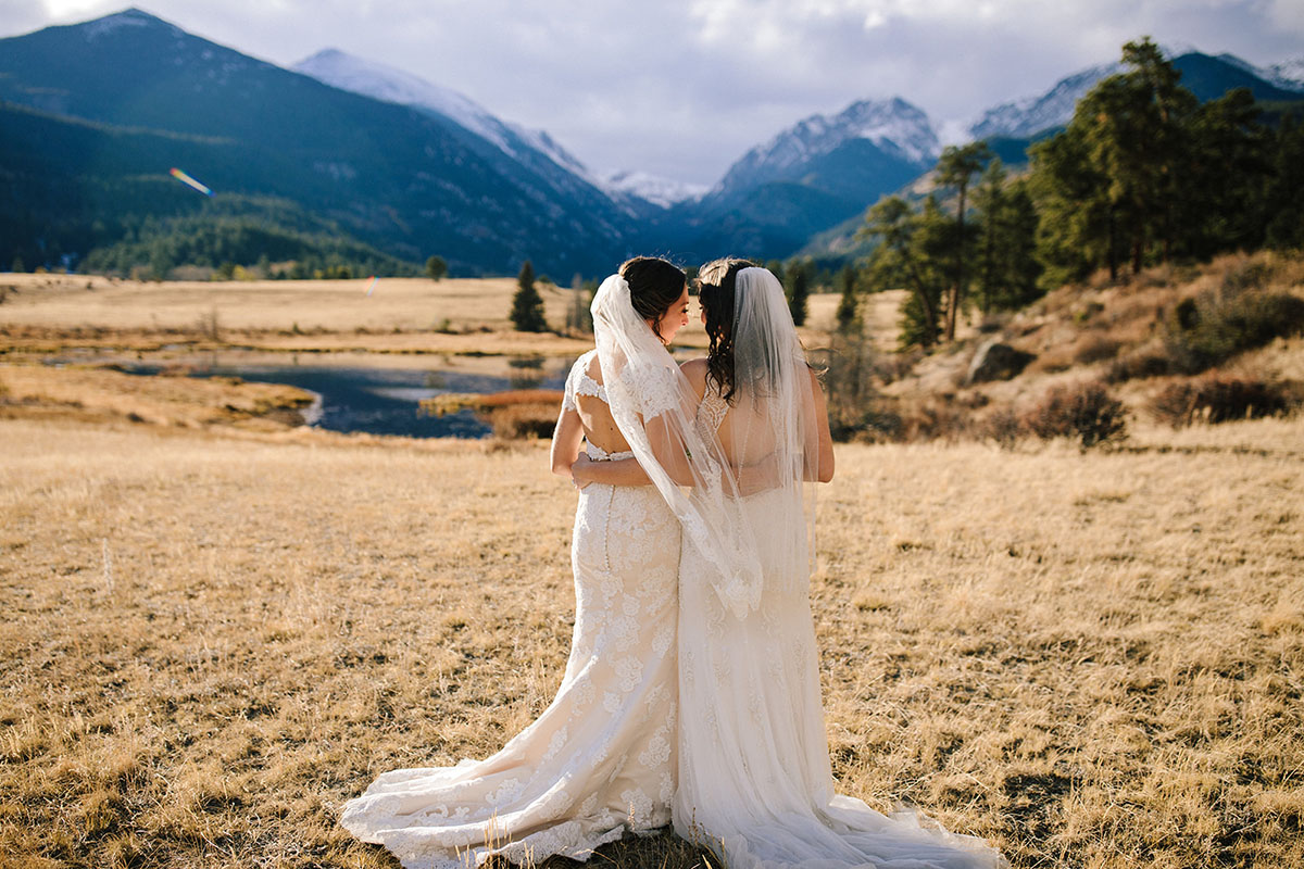 Rustic mountain wedding in the Colorado Rocky Mountains two brides lace whi...