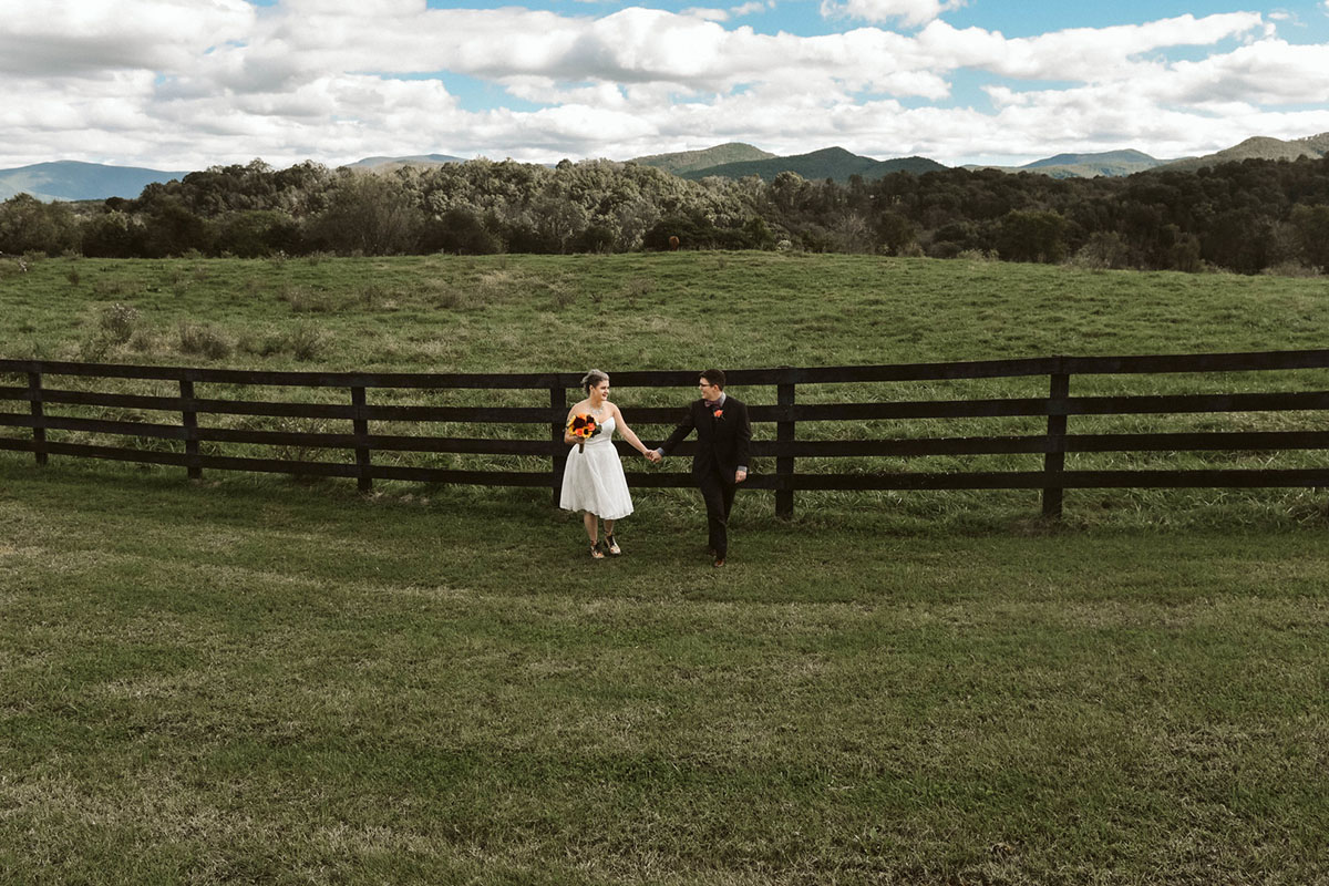 This moody fall ranch wedding in the Blue Ridge Mountains is a dream two brides lesbian wedding colorful boots roller derby skates purple bow tie dark tux white tea length dress crystal necklace rainbow