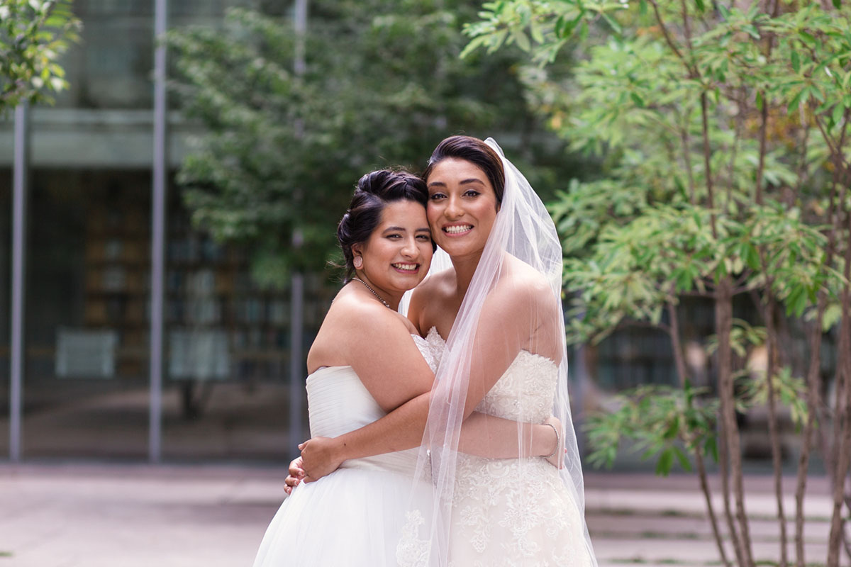Colorful summer nature-inspired loft wedding in Chicago, Illinois two brides lesbian wedding urban industrial David's Bridal dresses sunflower bright bouquets