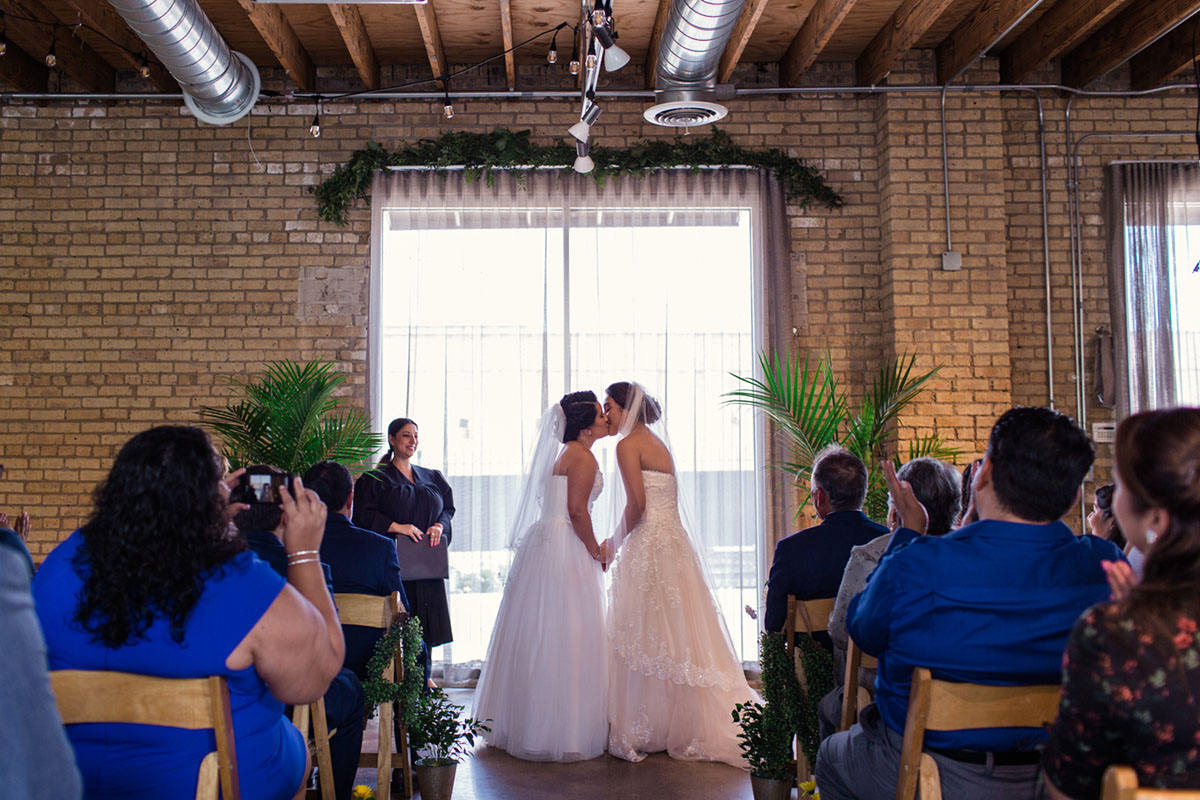 Colorful summer nature-inspired loft wedding in Chicago, Illinois two brides lesbian wedding urban industrial David's Bridal dresses sunflower bright bouquets DIY