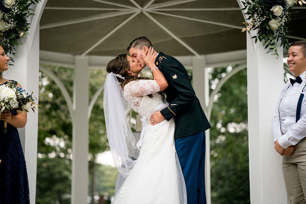 Early summer military farm wedding in Kettering, Ohio two brides military wedding blues U.S. army long lace white dress farmhouse kiss