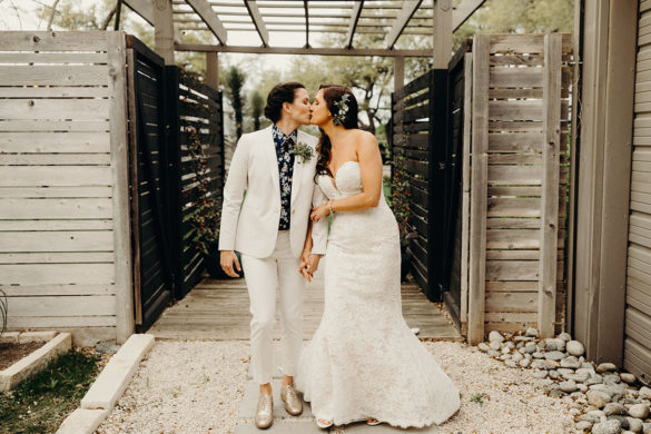 This is what it's like getting married 4 years after marriage equality two brides white suit long white strapless dress florals outdoor Texas gay lesbian wedding kiss