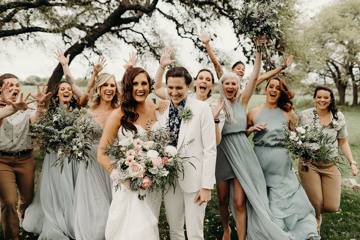 This is what it's like getting married 4 years after marriage equality two brides white suit long white strapless dress florals outdoor Texas gay lesbian wedding wedding party