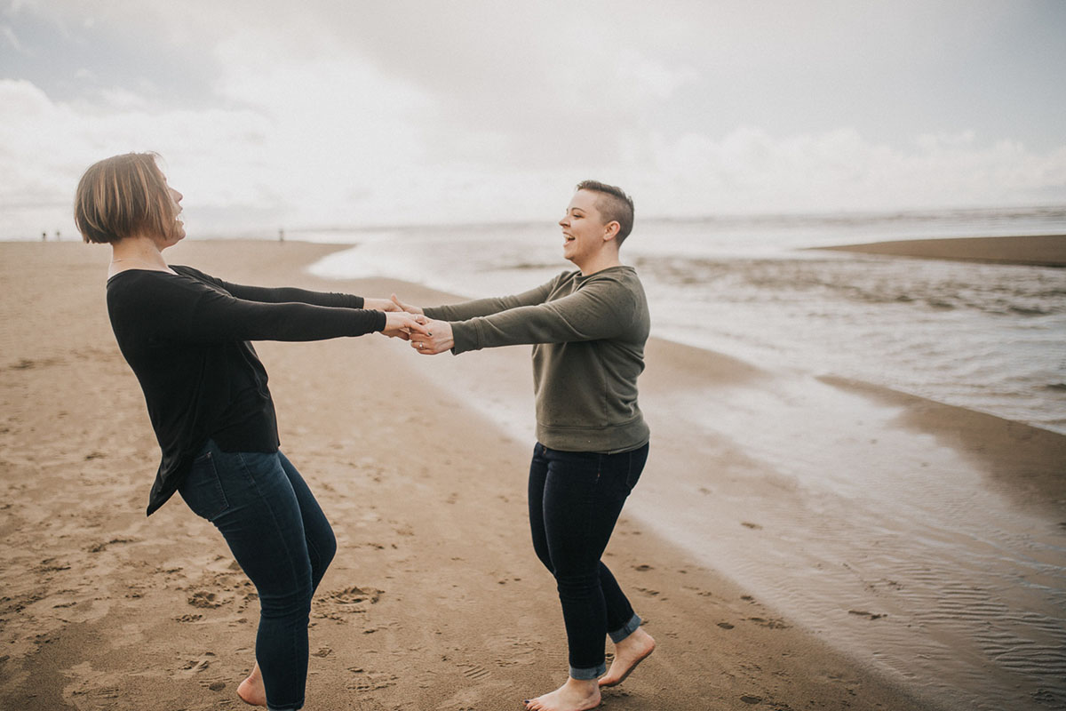 Romantic beach engagement photos on the Oregon Coast two brides Cannon Beach waterfront oceanside