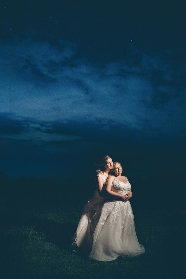 This fall countryside wedding has all the moody, romantic vibes you need two brides lesbian wedding autumn long white dresses night