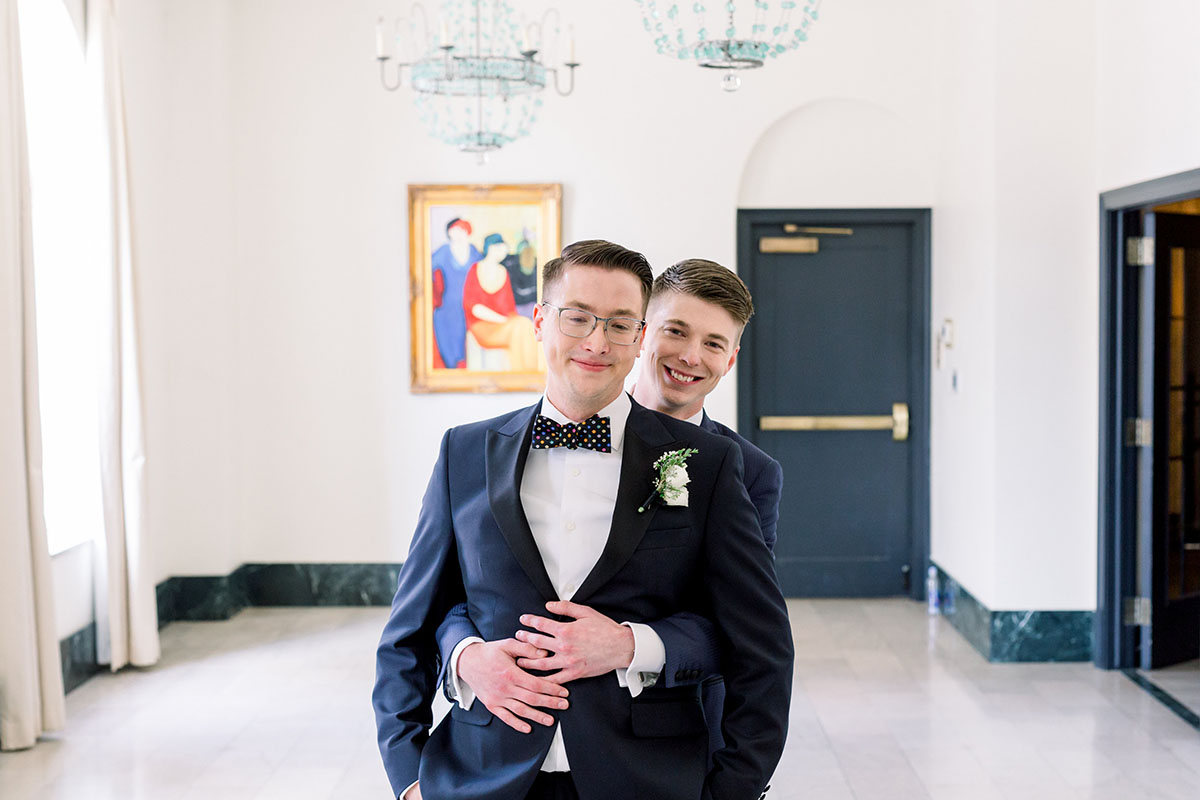 Elegant luxe historic hotel wedding in Tulsa, Oklahoma two grooms tuxedos bow ties luxurious gay wedding first look