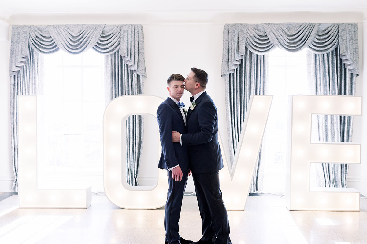 Elegant luxe historic hotel wedding in Tulsa, Oklahoma two grooms tuxedos bow ties luxurious gay wedding
