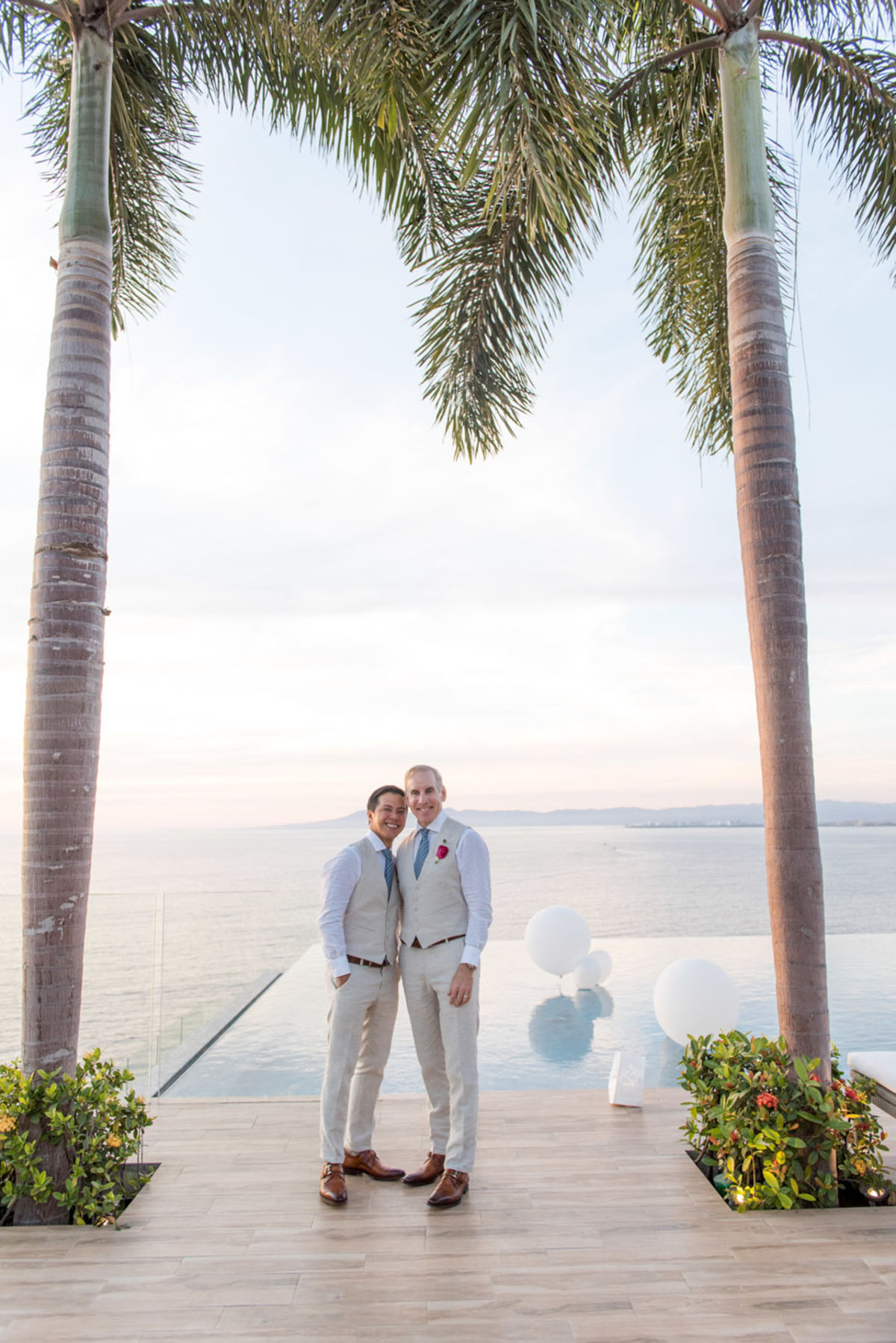 Tropical destination white beach wedding in Puerto Vallarta, Mexico two grooms linen tailored suits tradition whimsical palm trees