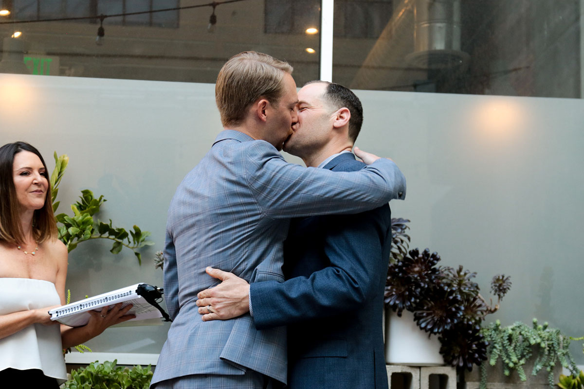 Urban bohemian spring wedding in Long Beach, California two grooms gay wedding donuts gray tux black tux burgundy ties kiss