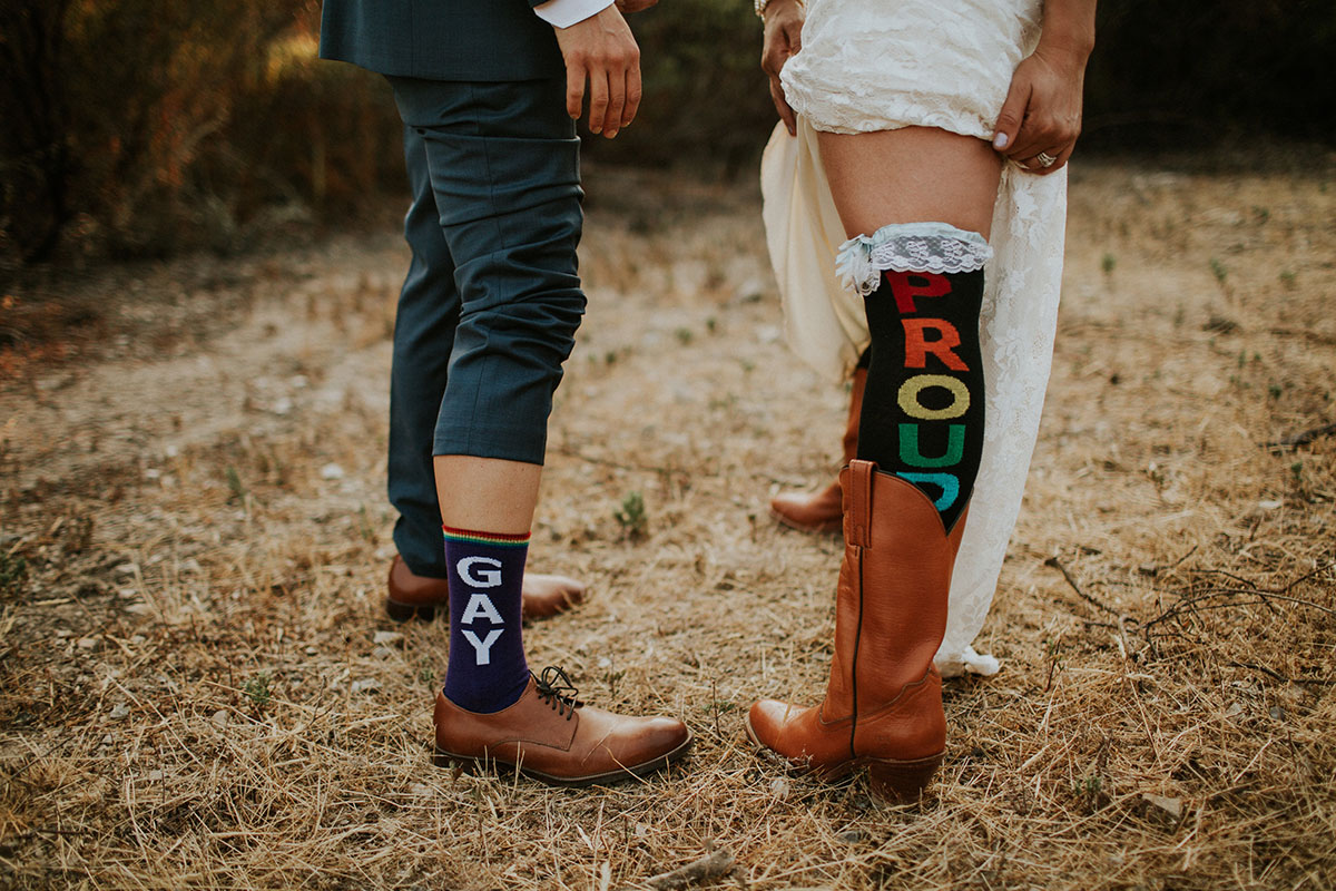 Mediterranean and Jewish wedding in wine country two brides same-sex lesbian wedding California long white dress gray lace suit proud gay rainbow socks cowboy boots