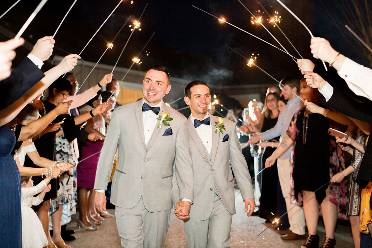 Blue and yellow spring wedding at the Lake Country Club two grooms gay wedding gray tuxes sparkler exit