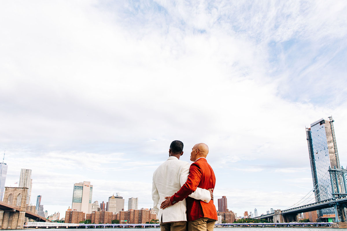Colorful red and white engagement photos in Brooklyn, New York red suit two grooms husbands Brooklyn Bridge New York City