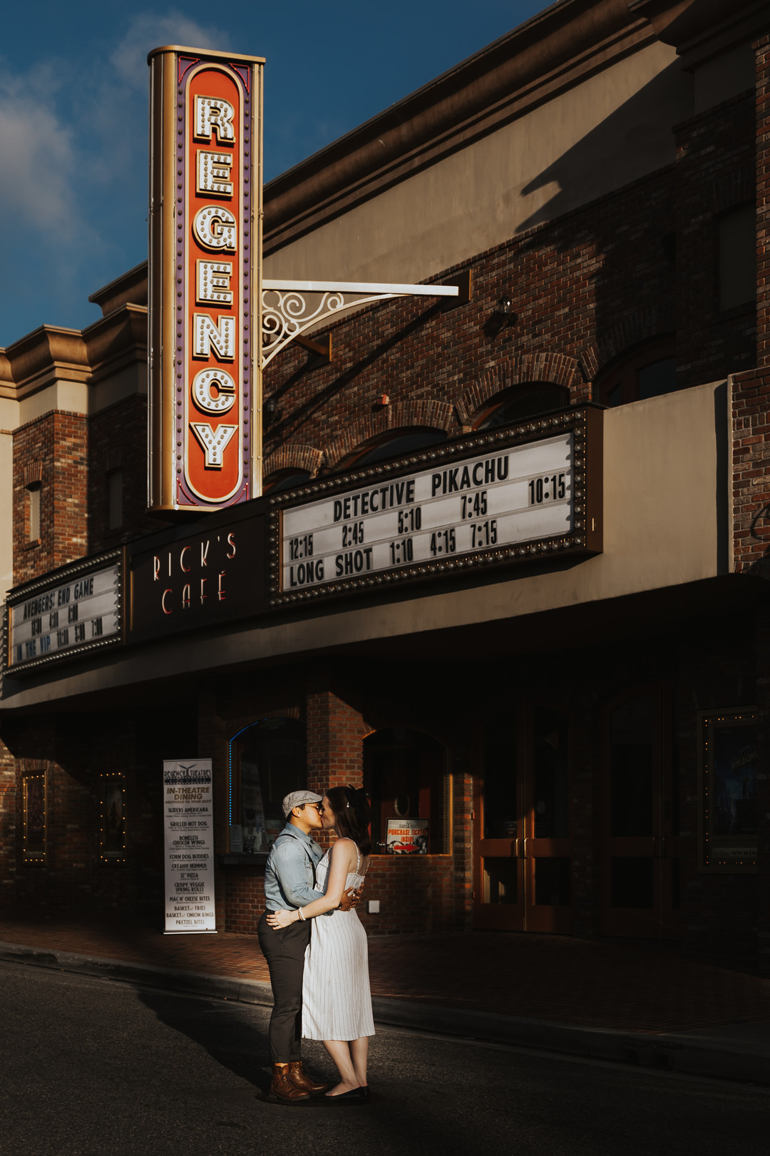 Engagement photos in the historic Los Rios district in California engaged two brides striped dress suspenders boots cuddling movie theater