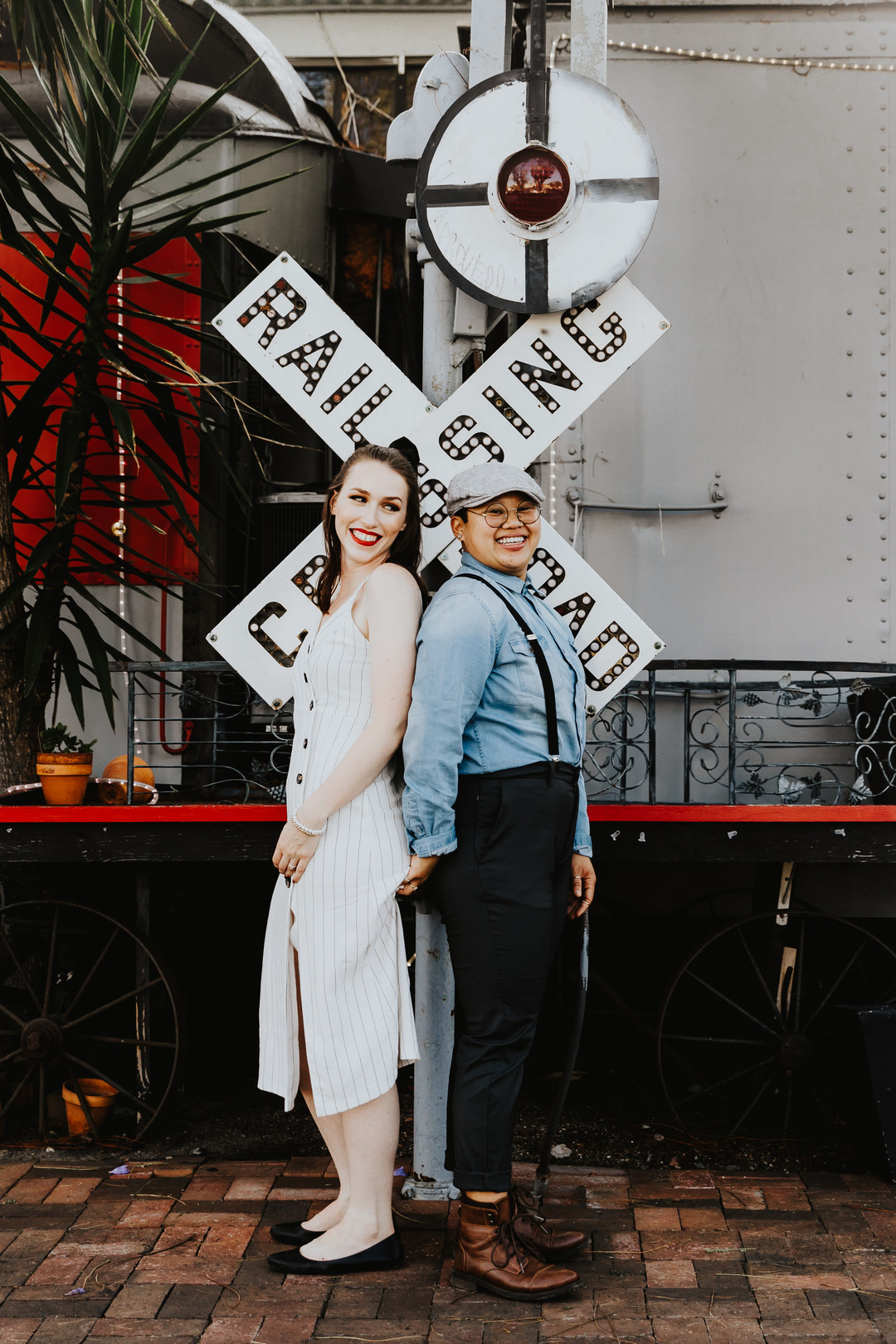 Engagement photos in the historic Los Rios district in California engaged two brides striped dress suspenders boots cuddling railroad