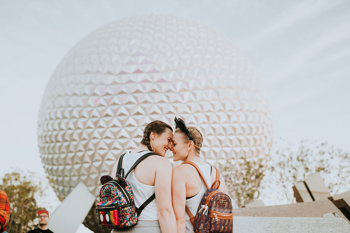 Fun, colorful engagement photos at Walt Disney World colorful red mouse ears coordinated outfits two brides same-sex lesbian engagement Epcot