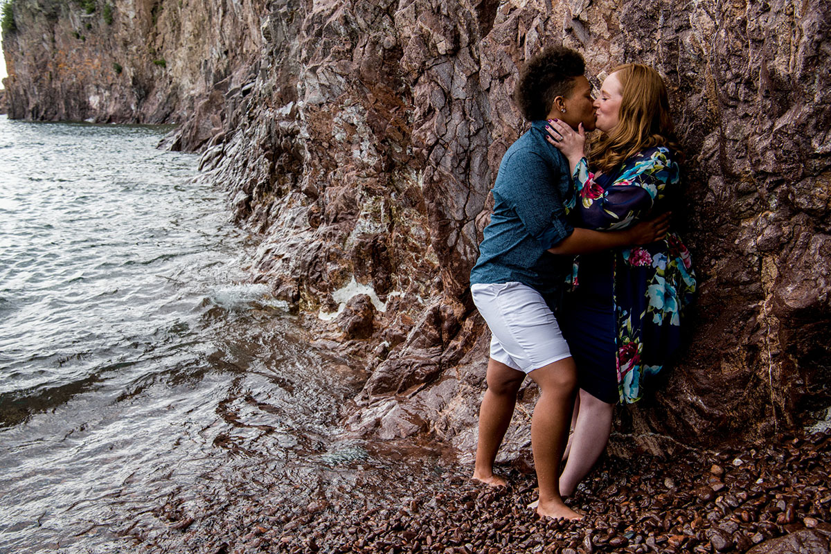 Fun waterfront engagement photos on the coast of Lake Superior rocks waves kissing