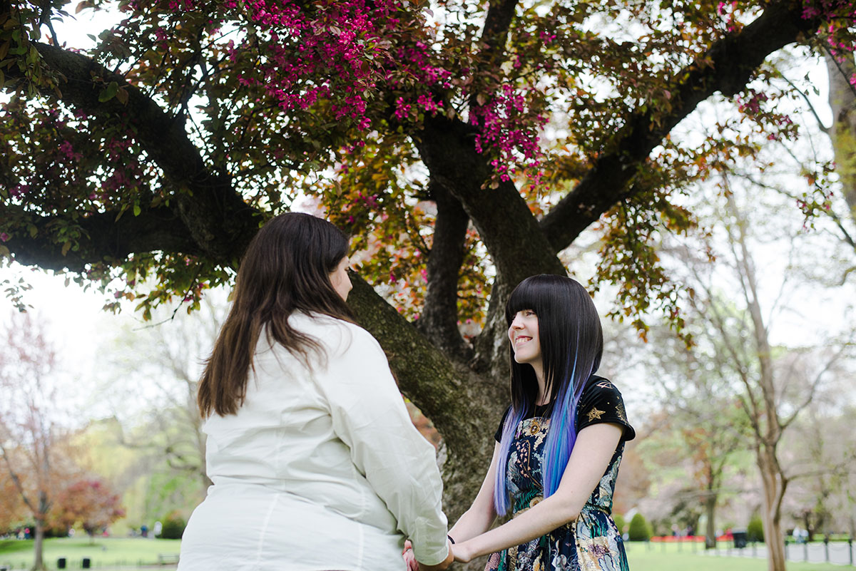 Spring engagement photos in Boston Public Garden two brides blooming trees flowers colorful