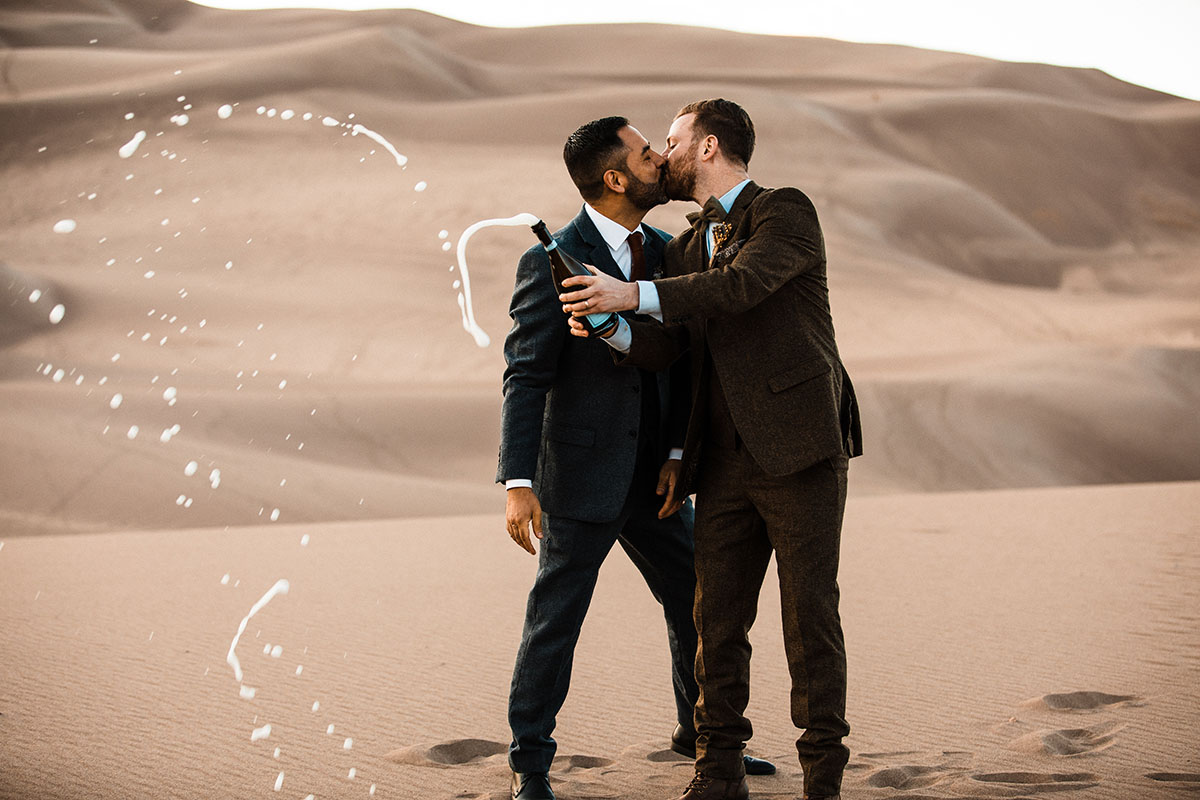 Sunset and sand dunes adventure elopement two grooms suits gay wedding intimate nature champagne