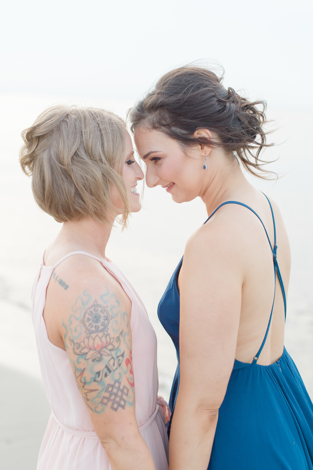 Beach engagement photos at Bayshore Waterfront Park two brides same-sex engagement pink dress blue dress emnrace