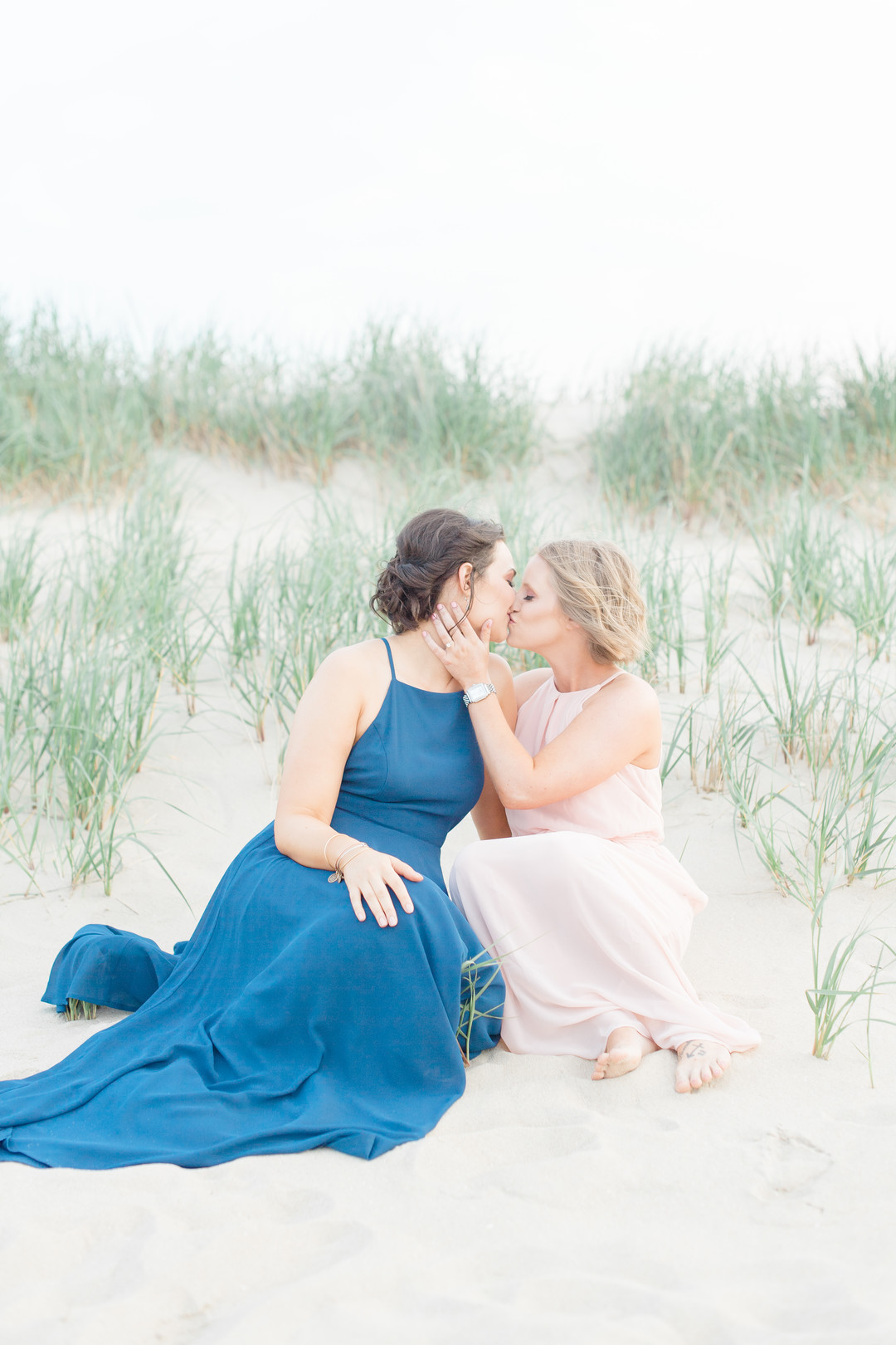 Beach engagement photos at Bayshore Waterfront Park two brides same-sex engagement pink dress blue dress dunes